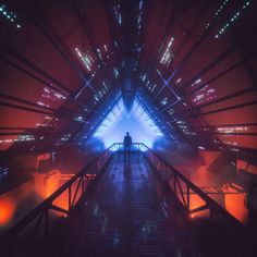 a man standing on top of a metal bridge