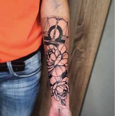 a woman's arm with flowers on it and the letter q in black ink