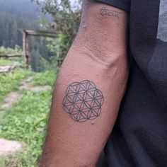 a man's arm with a tattoo on it that looks like a flower of life