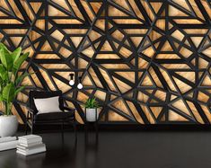 a black chair and some plants in front of a wall with wooden panels on it