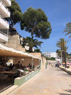 people are sitting at tables on the beach