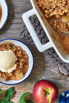 an apple cobbler with ice cream on top and two plates full of desserts next to it