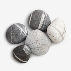 five marble rocks arranged in a row on a white background