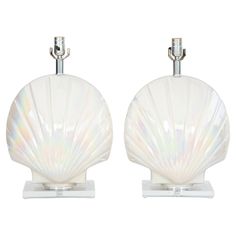 two white shell shaped lamps sitting on top of each other in front of a white background