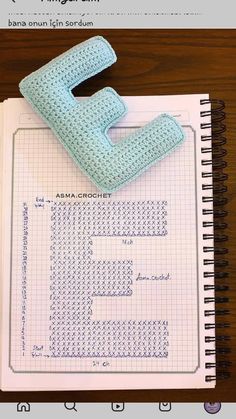 a notebook with a crocheted letter on it