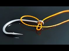 a fishing hook with an orange handle and two white hooks on it's end