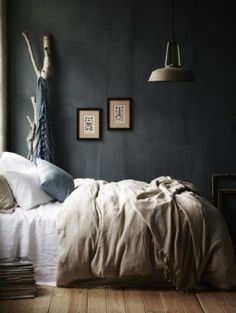 a bed sitting in a bedroom next to a window with two framed pictures on the wall