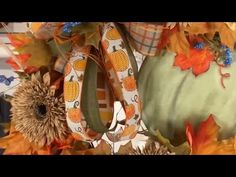 an arrangement of fall decorations with pumpkins and leaves