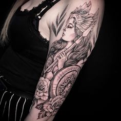 a woman with a clock and roses tattoo on her arm