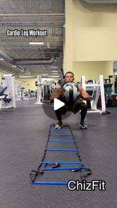 a man squats on the ground while holding a medicine ball in front of him