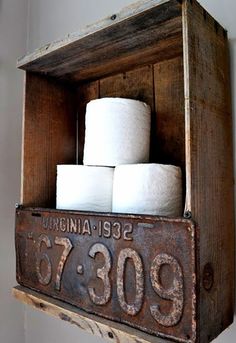 an old wooden box holding several rolls of toilet paper