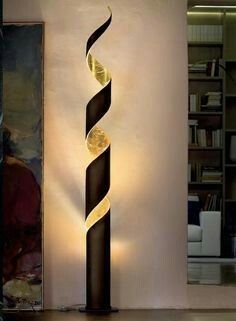 a tall black and gold lamp sitting next to a painting