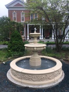 a water fountain in front of a large house