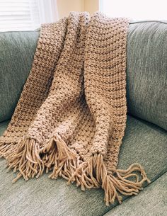 a crocheted blanket sitting on top of a couch