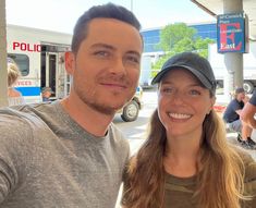 a man and woman posing for a photo in front of a food truck at a gas station