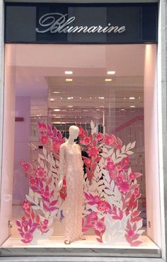 a window display with pink and white paper flowers