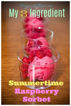 three cups filled with raspberry sorbet on top of a wooden table