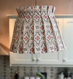 a lamp shade hanging from the ceiling in a kitchen