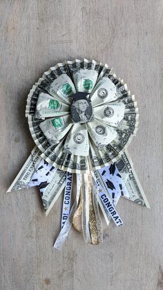 a fan made out of dollar bills sitting on top of a wooden table next to scissors