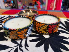 two candles sitting on top of a table next to each other