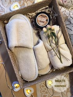 an open box filled with white slippers and candles