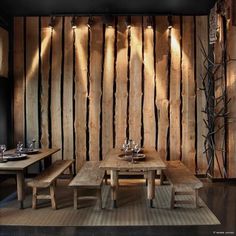 a wooden table and benches in a room with wood paneling on the wall behind it