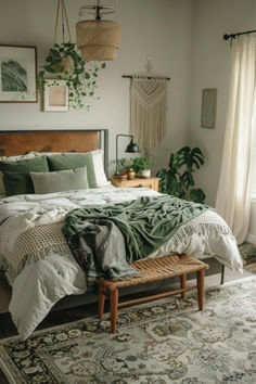 a bedroom with a large bed covered in green blankets and pillows, along with hanging plants