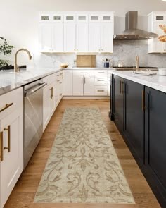 a kitchen with white cabinets and wooden flooring, along with a beige runner rug