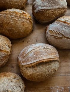 several loaves of bread sitting on top of a wooden table