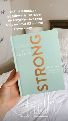 a person holding up a book in their hand with the title strong written on it