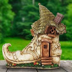 a ceramic shoe shaped like a house with a thatched roof and a door on the side