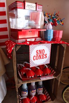 there is a red cart with some condiments on it and a sign that says sno cones