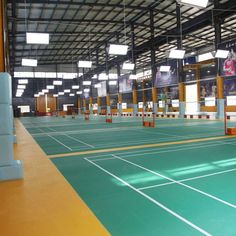 an indoor tennis court with green and yellow flooring