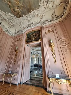 an ornately decorated room with pink walls and gold trimmings on the ceiling