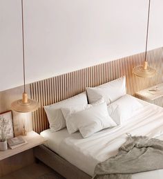 a bed with white sheets and pillows in a bedroom next to two lamps on either side of the bed