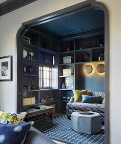 a living room filled with furniture and bookshelves next to a wall mounted book shelf