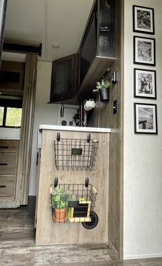 a kitchen area with potted plants and pictures on the wall