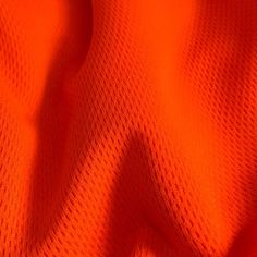 an orange fabric textured with small squares and lines, as well as the background