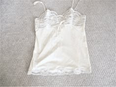 This vintage Formfit Rogers camisole top is a size 34. It measures 14.5 inches seam to seam under the bust laid flat and 25 inches from the top of the strap to the bottom of the lace. It is a pale pink with ivory floral lace on the bodice and scalloped lace on the hem.  The tag reads size 34 and 12 - 14, Made in U.S.A. Excellent condition with no flaws. Fitted Cream Camisole With Built-in Bra, Fitted Cream Tank Top With Built-in Bra, Cream Camisole With Built-in Bra And Spaghetti Straps, Beige Camisole Tank Top For Daywear, Cream Camisole With Adjustable Spaghetti Straps, Cream Camisole Top With Built-in Bra, White Tank Camisole With Delicate Straps, Beige Camisole Top For Daywear, Vintage Sleeveless Camisole With Built-in Bra