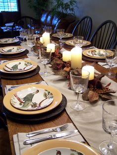 a table set with place settings and candles