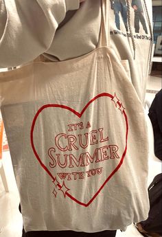 a person holding a bag that says it's a cruel summer with you