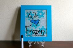 a blue frame sitting on top of a table next to a white pen and eraser