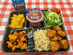 a tray with rice, meat and vegetables on it next to a carton of mayonnaise