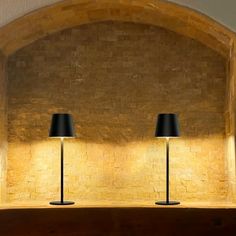 two lamps sitting on top of a wooden shelf