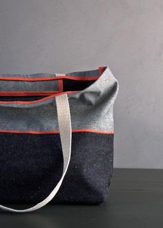 a gray and red bag sitting on top of a table