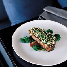 a white plate topped with food on top of a black table next to a blue couch