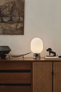 a lamp sitting on top of a wooden dresser