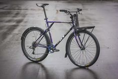 a purple bike is parked in the rain