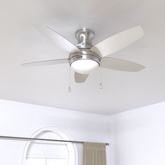 a ceiling fan in a white room next to a window