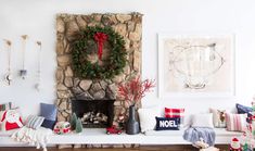 a living room decorated for christmas with wreaths and decorations on the fireplace mantel